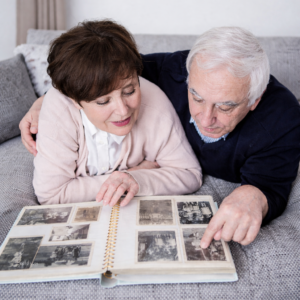 Older couple looking at photo album illustrating memory recall and cognitive aging associated with aging brain disorders